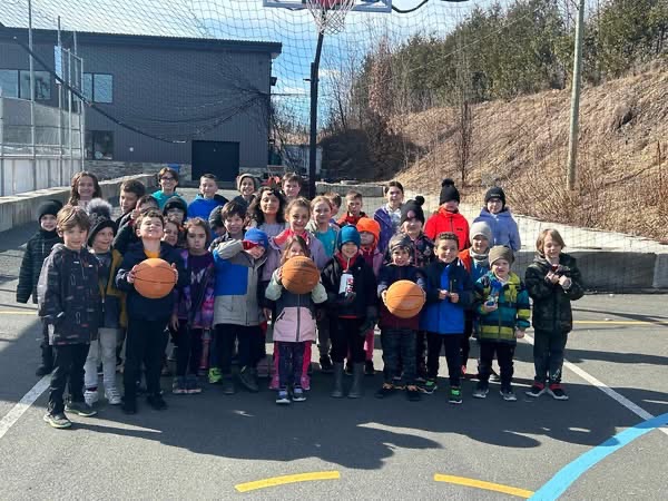 Des campeurs réunis dehors avec des ballons de basketball