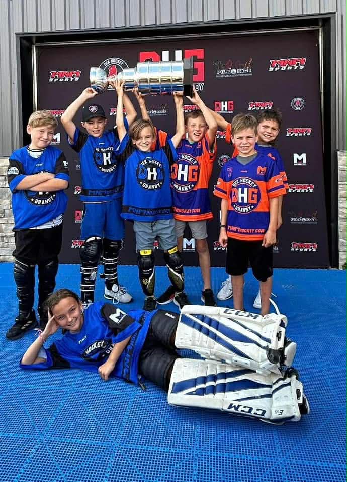 Une équipe de jeunes joueurs célèbre avec un trophée au DHG